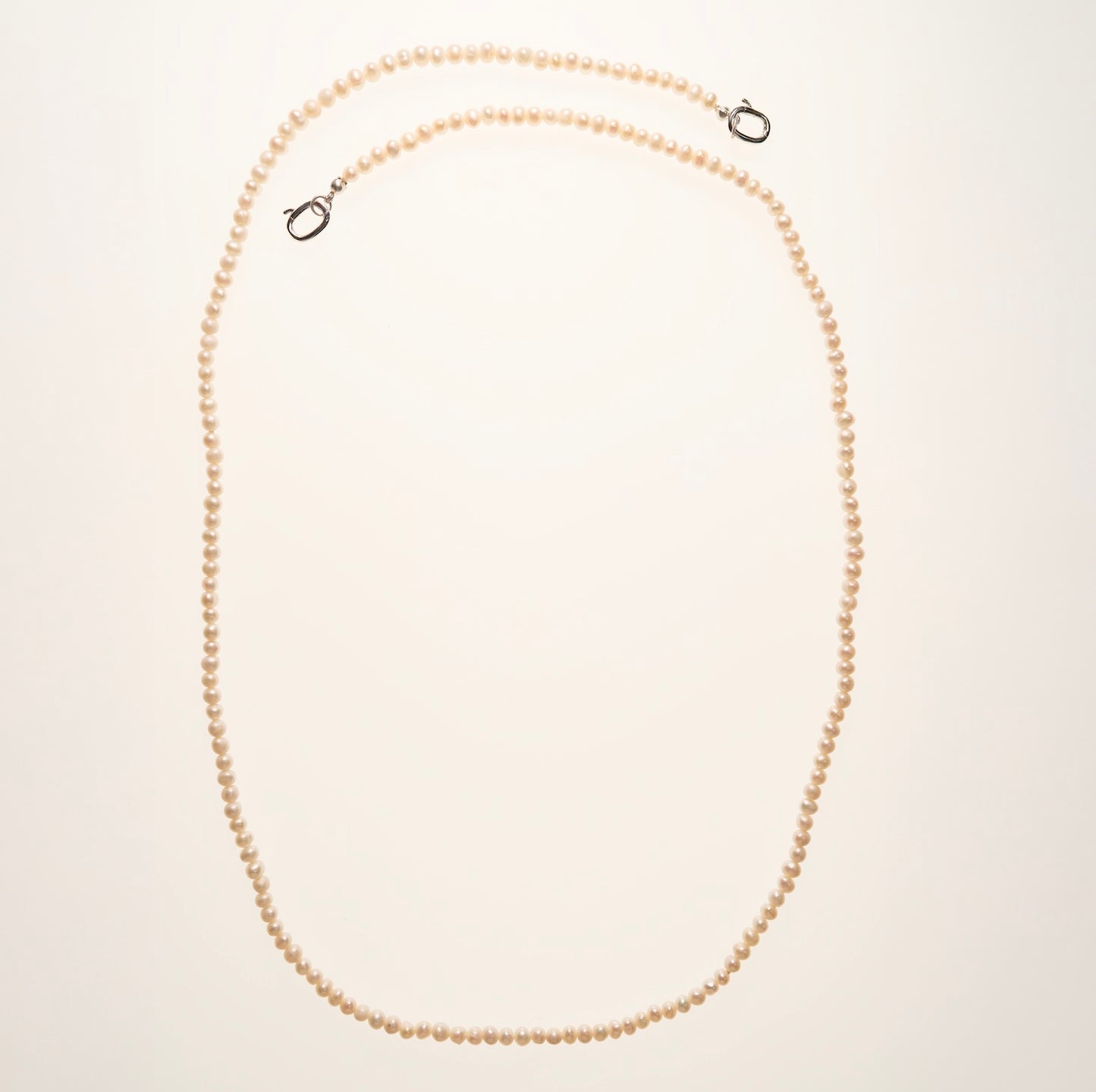 Pearl necklace on a light beige background